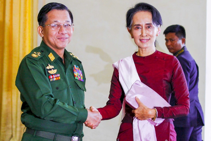 Min Aung Hlaing in military dress uniform shaking hands with a smiling Aung San Suu Kyi
