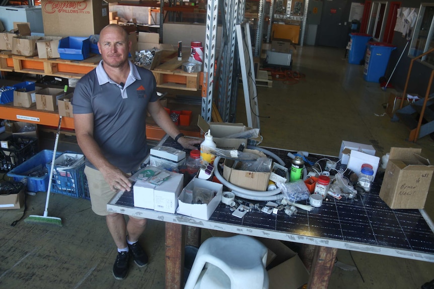 Jeremy Hunt stands next to a table he made out of a broken solar panel