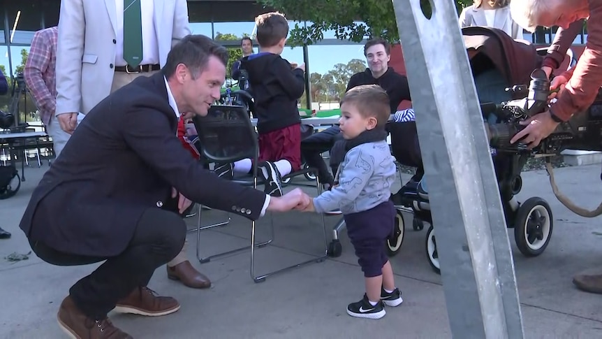 a man shaking a little child's hand