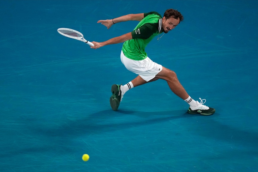 Daniil Medvedev hits a running slice backhand at the Australian Open.