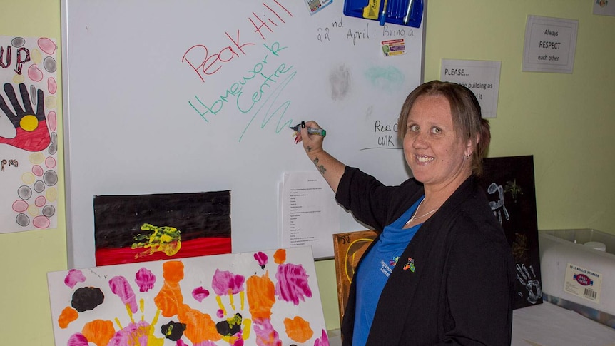 Aboriginal Youth and Family worker, Janice Millett, writes on a white board at the Peak Hill Homework Centre in central NSW