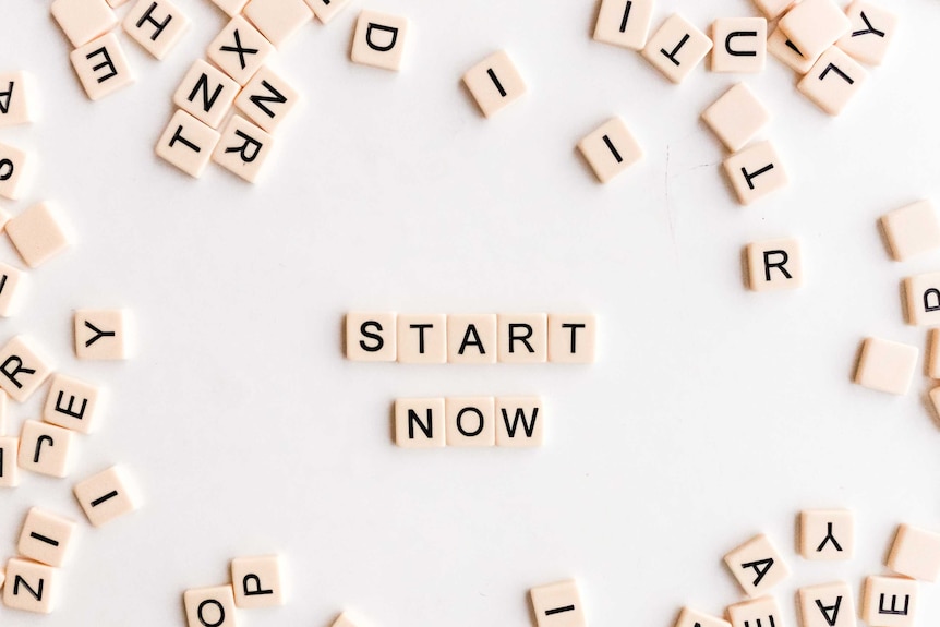 Scrabble letters spell out the words 'START NOW'