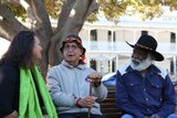 WA Indigenous leaders Carol Innes, Ben Taylor and Glen Cooke sit on a park bench talking to eachother.
