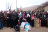 Syrians wait for the arrival of an aid convoy in the besieged town of Madaya