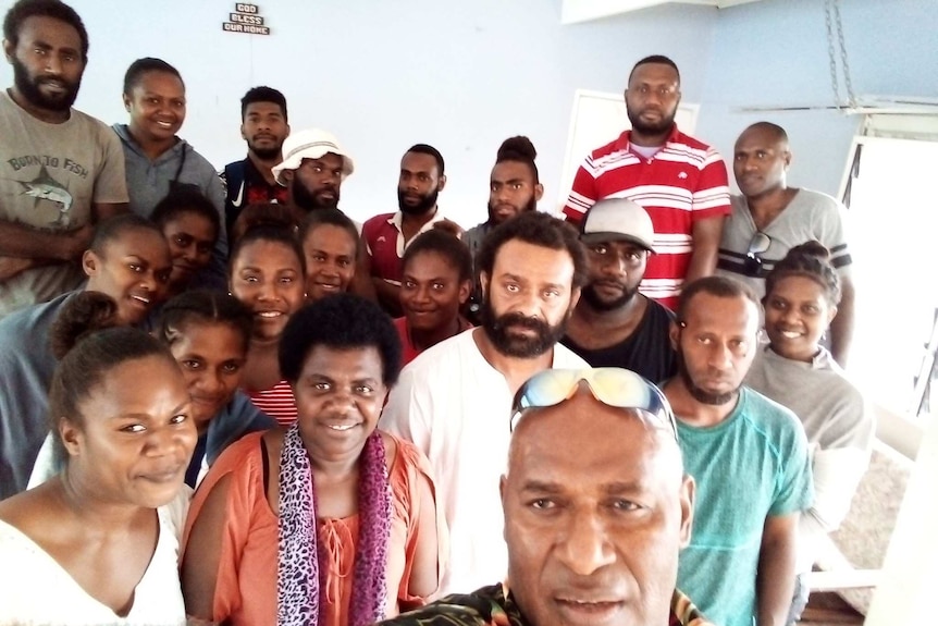 A group of people pose for a selfie inside in Vanuatu.