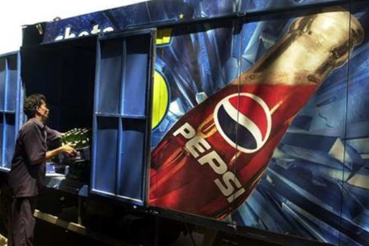 A worker loads crates of small Pepsi bottles into a Pepsi truck in Bombay, India.