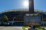 A sign reading "Sun event closed to public" sits outside Optus Stadium before the AFL game between West Coast and Fremantle.