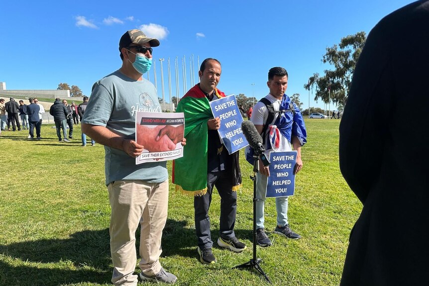 Three Afghan Australian men being interviewed in front of Parliament House in Canberra.