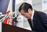 Yoshio Hachiro bows at a news conference to announce his resignation at the ministry
