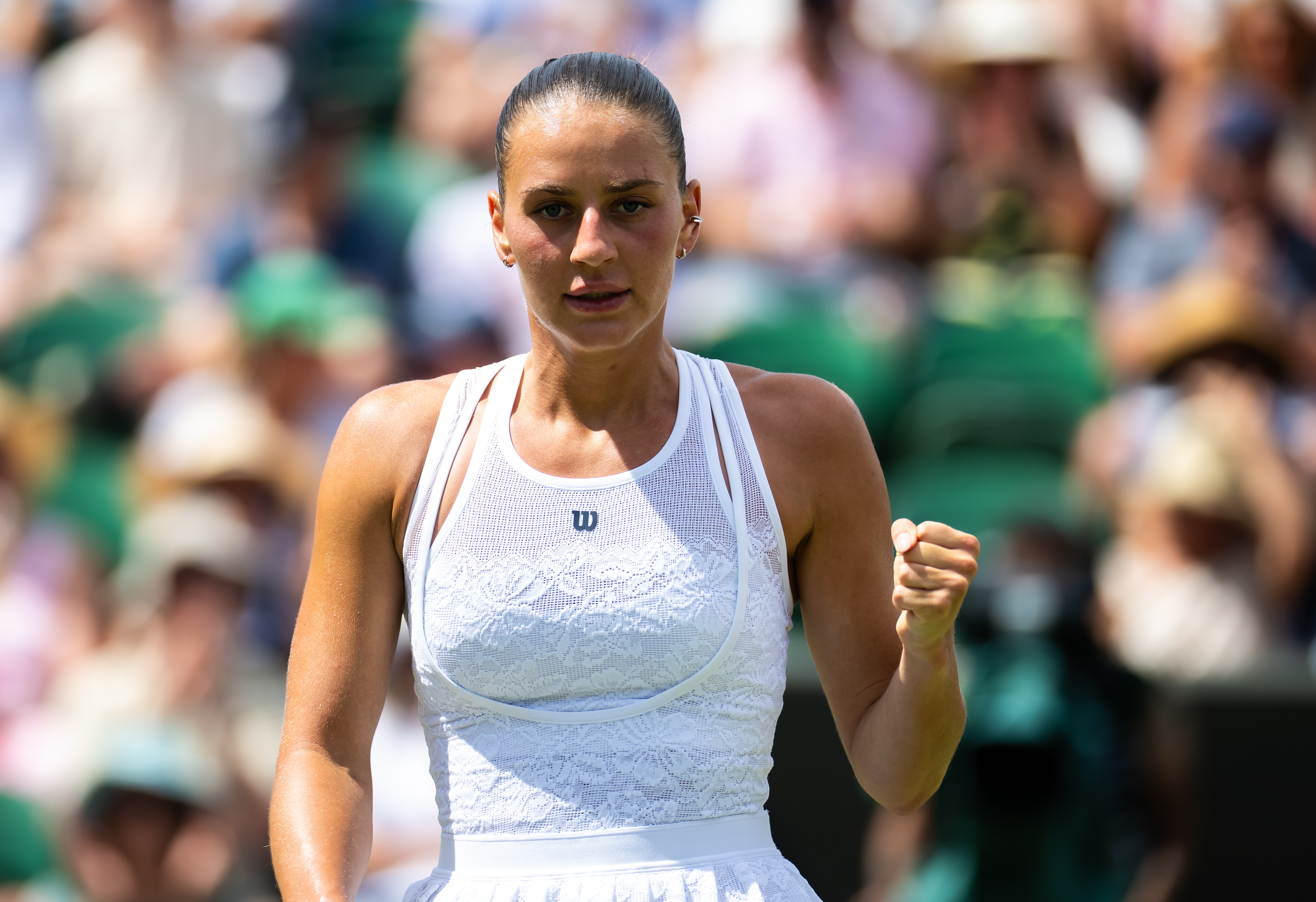 Marta Kostyuk clenches her fist after winning a point at Wimbledon.