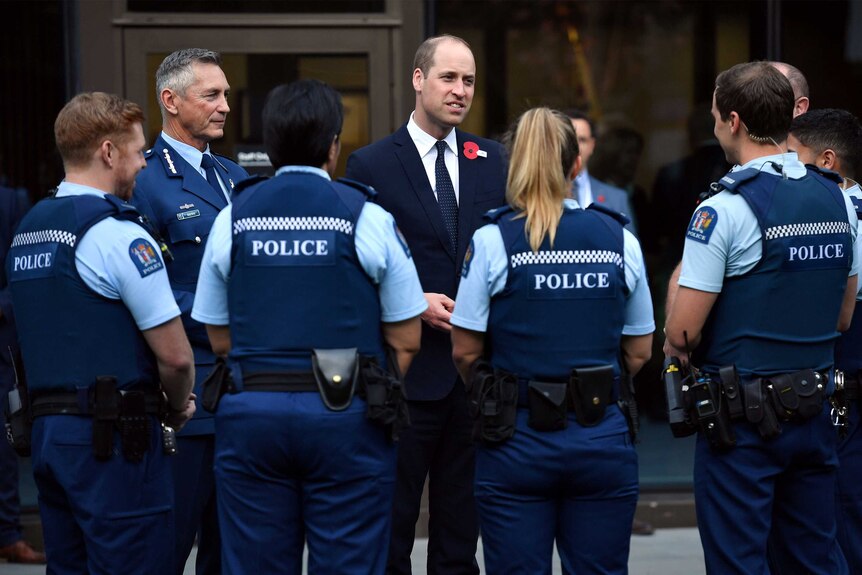 Prince William surrounded by uniformed police.