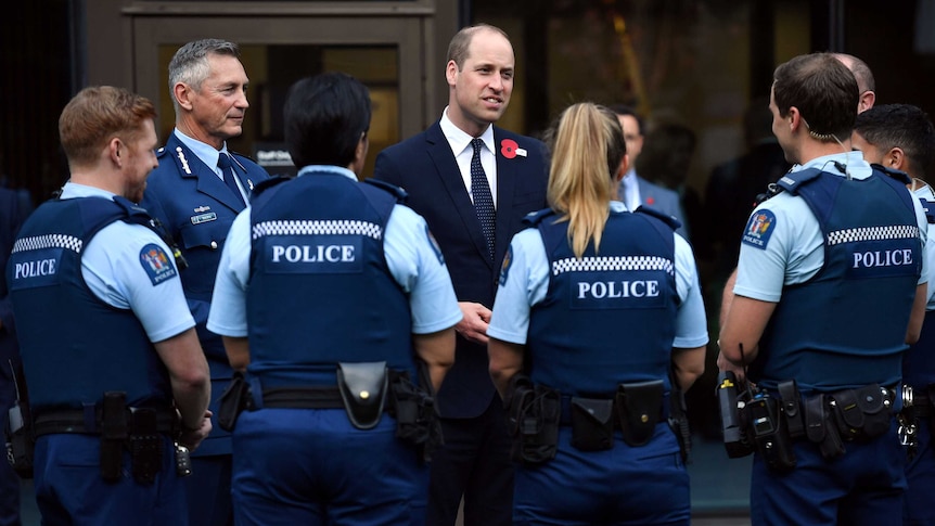 Prince William surrounded by uniformed police.