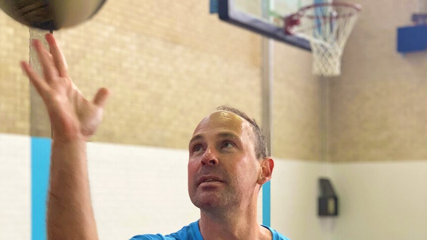 Canberra Capitals coach Paul Goriss spins a basketball on his finger.