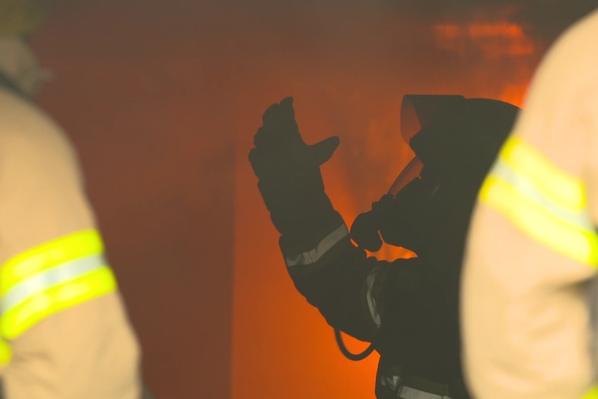 A silhouette of a firefighter among flames