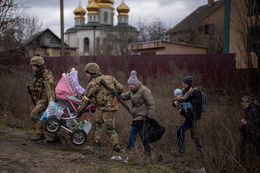 乌克兰士兵帮助一个逃亡家庭渡过伊尔宾河。