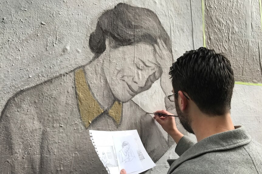 Melbourne artist James Bonnici helps paint a mural in Hosier Lane in Melbourne.