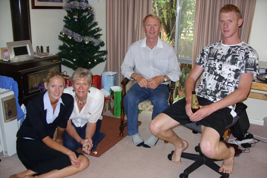 The Poate Family shown gathered around a Christmas tree