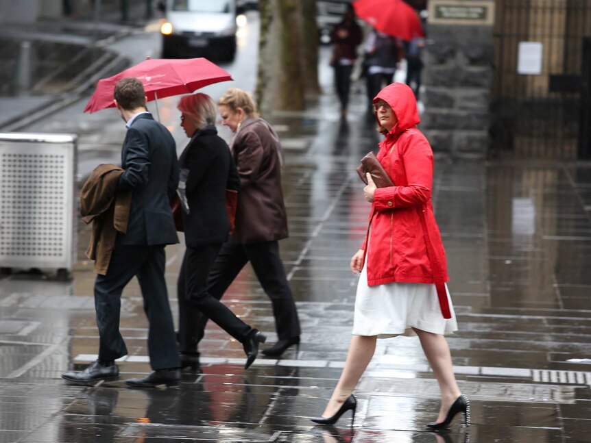 People with umbrellas on a rainy Melbourne day.