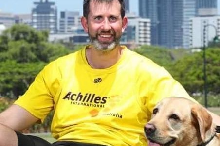 man in yellow shirt with golden labrador