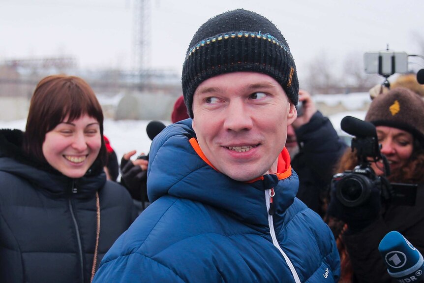 Russian opposition activist Ildar Dadin speaks to journalists as his wife Anastasia Zotova smiles.