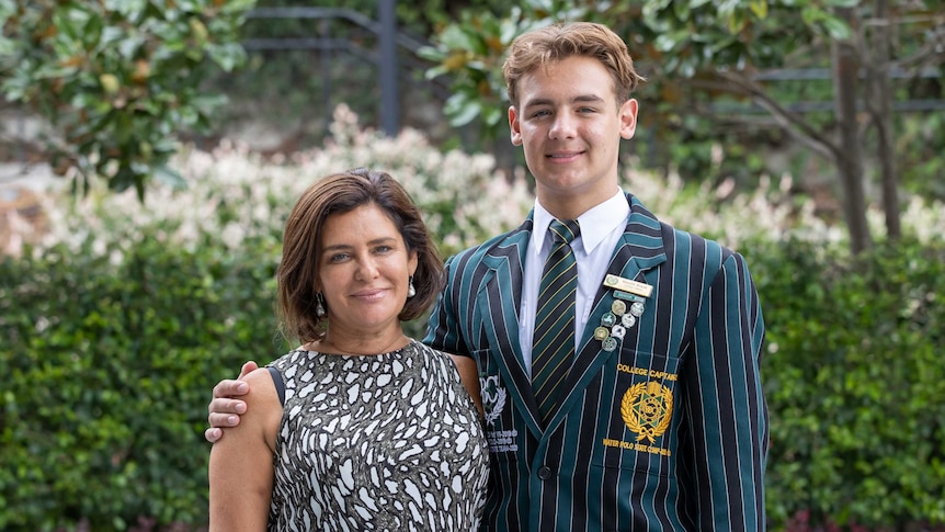 An image of a Brisbane Boys' College student Mason Black with his mother with leafy background.
