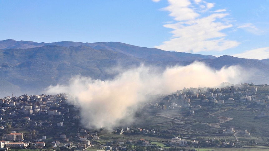 Smoke rises from village.