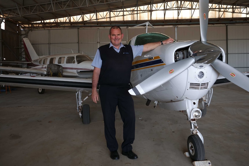 A man stands next to a plane.