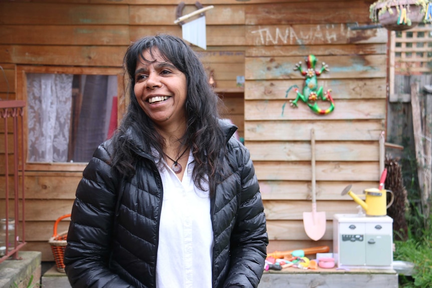 Sonya Singh laughs outside a cubby house in her backyard.