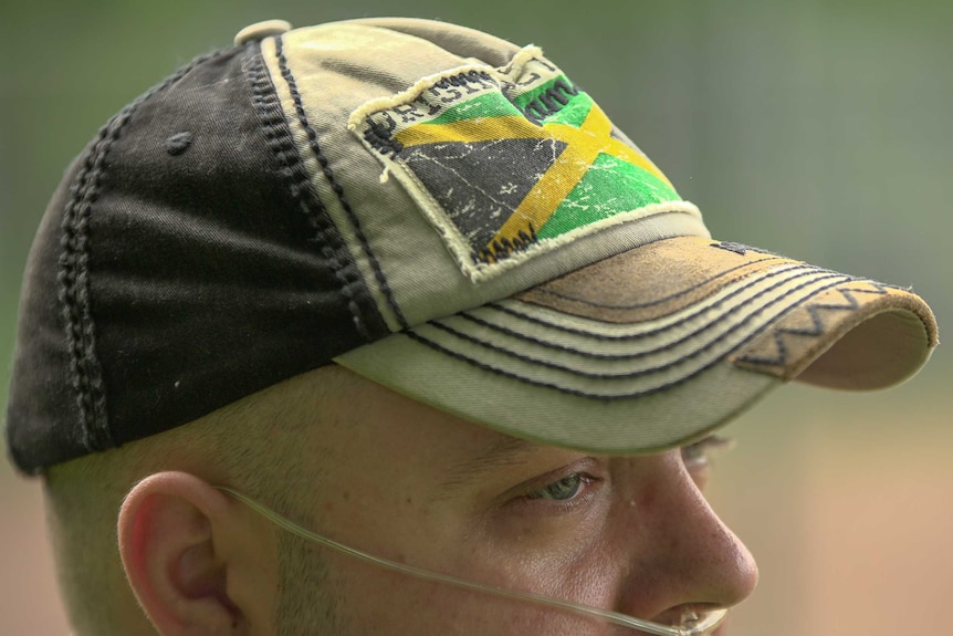 A close up of a man's baseball cap which bears the Jamaican flag
