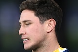 A close up of Mitchell Moses as he looks downwards
