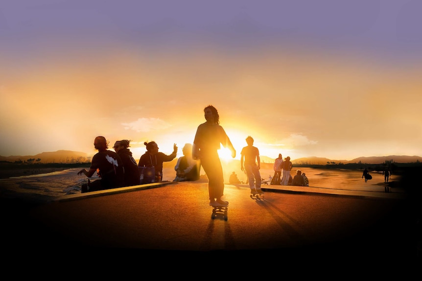 Surfers at sunset on a beach