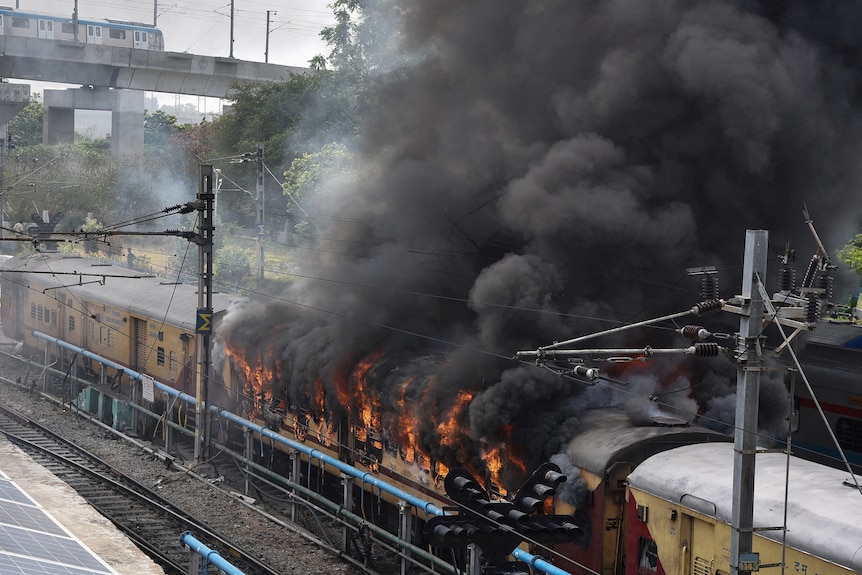 Thick black smoke billowing out of a passenger train.