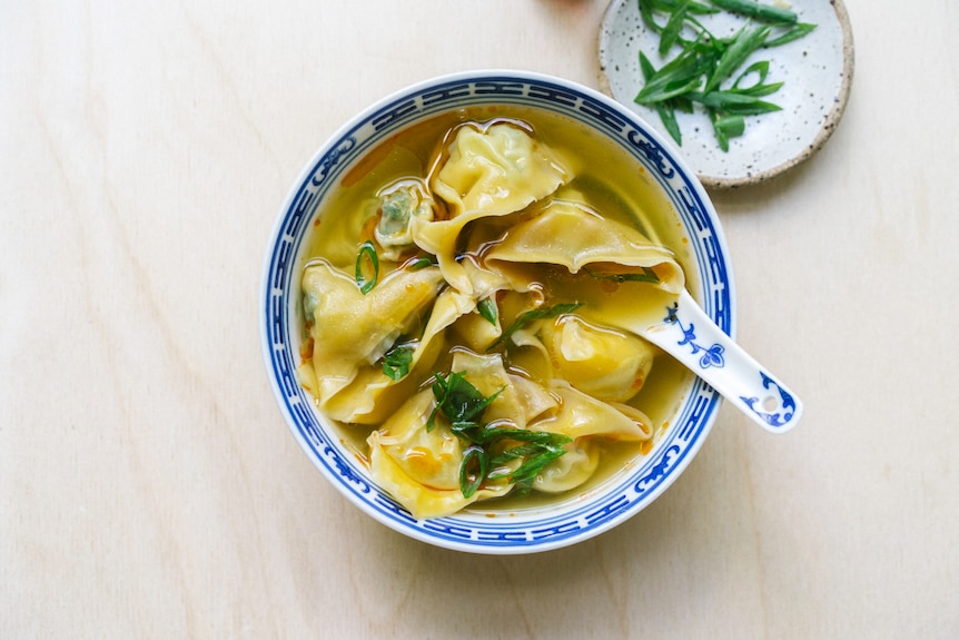 A bowl of wonton soup with potato and bok choy dumplings, a classic Chinese meal made vegetarian.