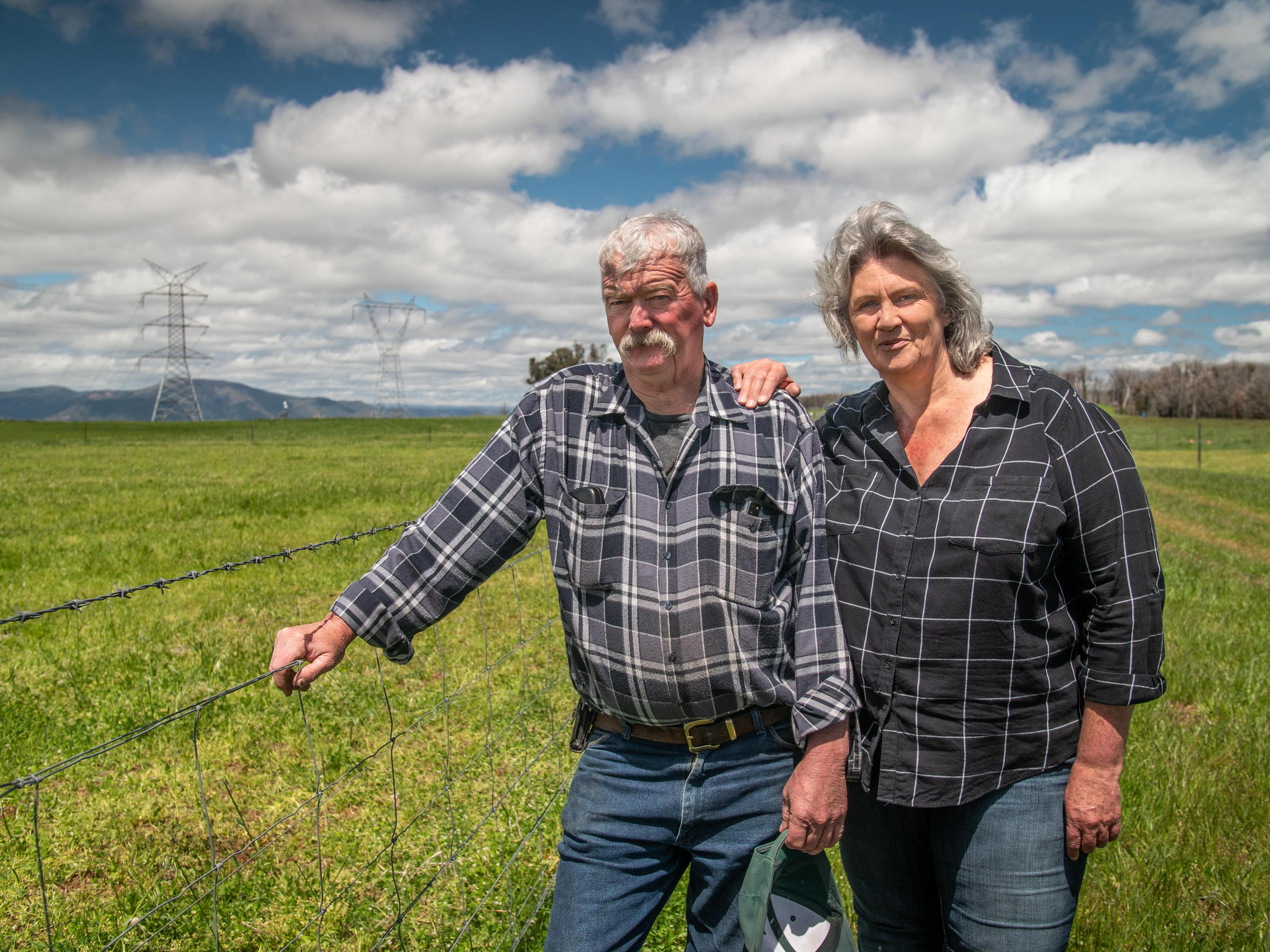Andrea and Paul Sturgess stand next to a fence.