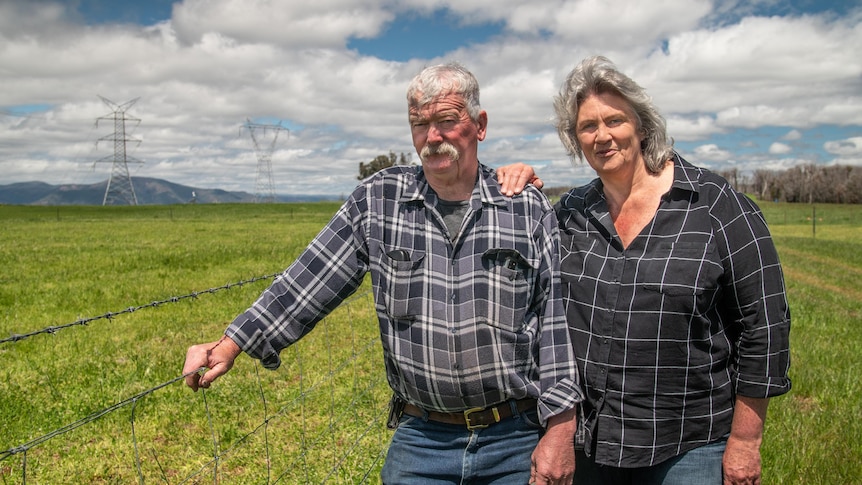 Andrea and Paul Sturgess stand next to a fence.