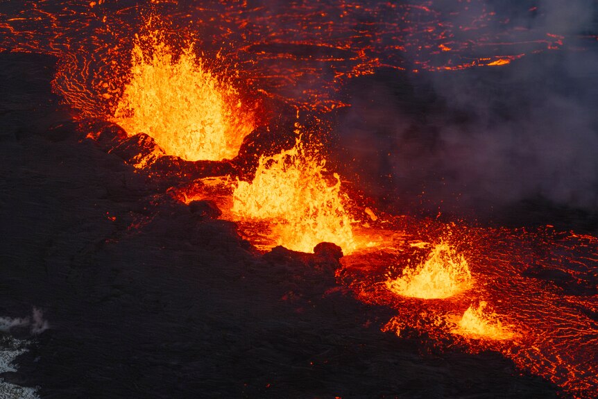 Four molten lava craters spewing magma 