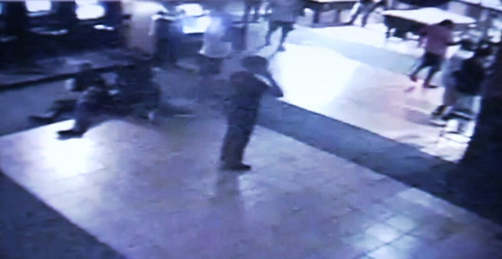 CCTV image shows three people on the floor and a person on a phone.