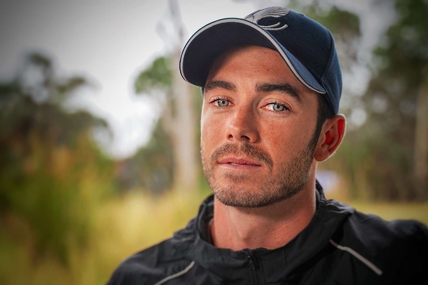 A man wearing a cap looking into the camera.