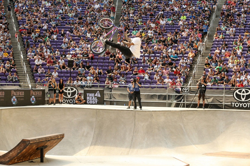 Professional freestyle BMX rider Logan Martin in the air during a jump in a skate bowl.
