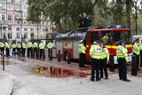 Extinction Rebellion climate activists stand on a fire engine outside the Treasury building in London