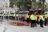 Extinction Rebellion climate activists stand on a fire engine outside the Treasury building in London