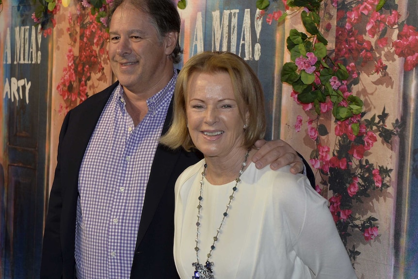 Abba's Anni-Frid Lyngstad stands with Henry Smith against Mamma Mia flowered backdrop
