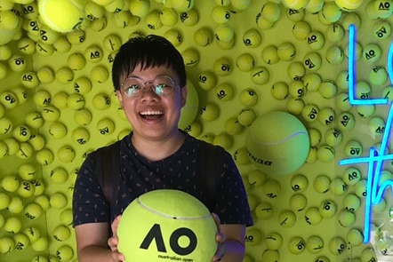 A person holding a giant tennis ball 