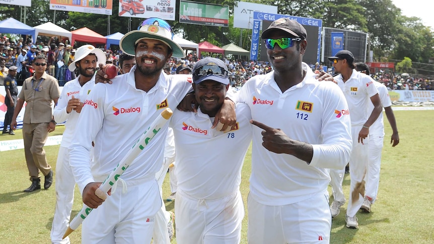 Sri Lanka's captain Angelo Mathews (R) celebrates with team-mates Rangana Herath (C) and Dinesh Chandimal after victory in the third and final Test.