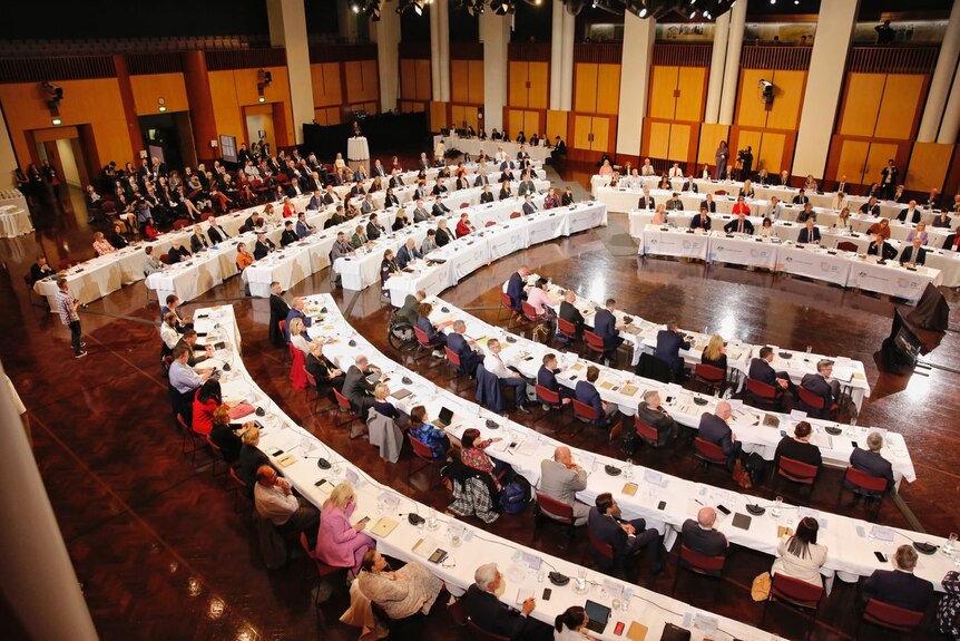 Business, union and community leaders sit in rows of tables and chairs that fill Parliament House's Great Hall.