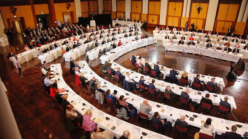 Business, union and community leaders sit in rows of tables and chairs that fill Parliament House's Great Hall.