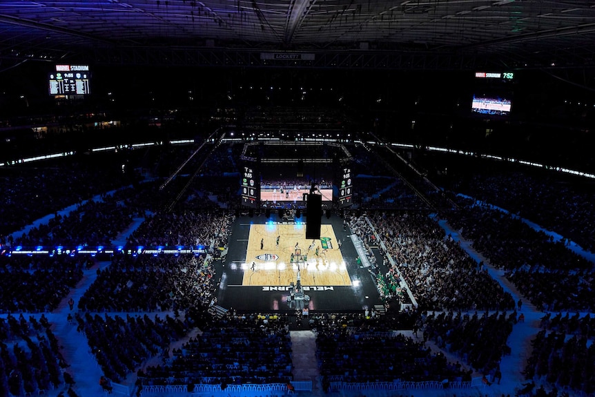 USA Basketball and Australia's Boomers play a basketball game. The players are just barely visible from this very high view.