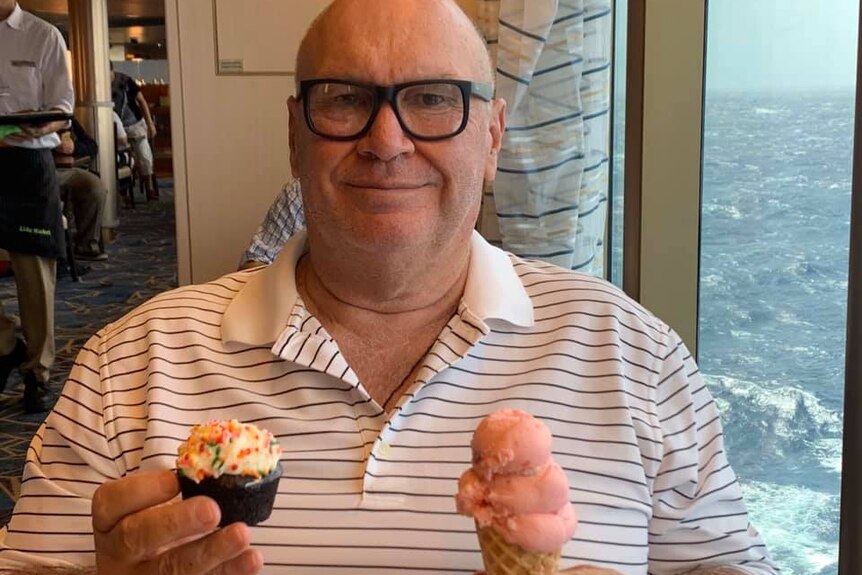 David Holst wearing black glasses and holding a cupcake and ice cream