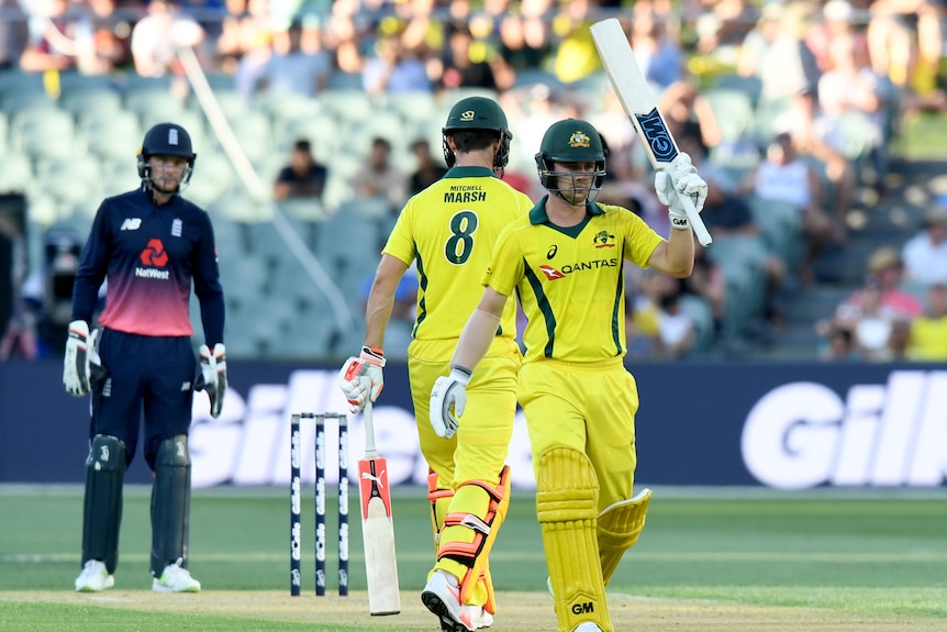 Travis Head raises his bat after making a half-century for Australia against England in Adelaide.