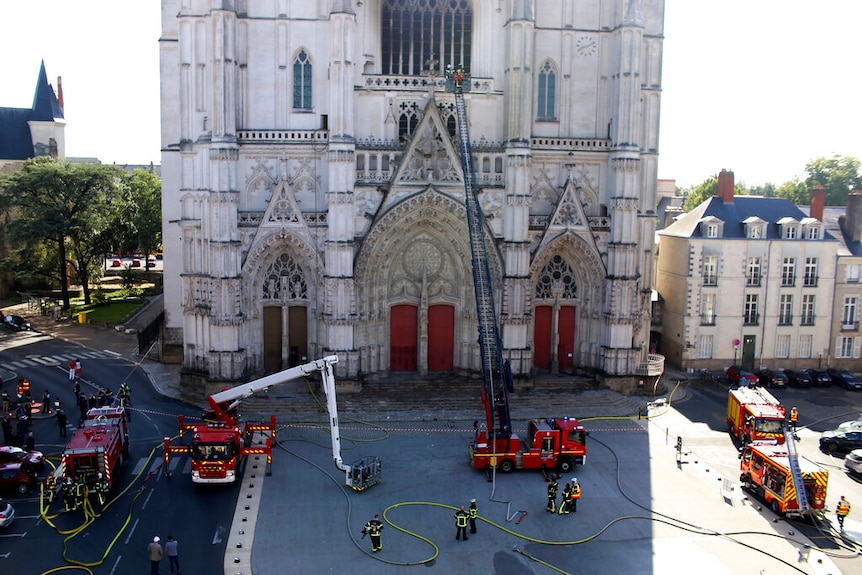 Fire fighters brigade work to extinguish the blaze at the Gothic St. Peter and St. Paul Cathedral, in Nantes, western France.